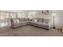 Spacious living room featuring a comfortable gray sectional sofa and neutral décor at 21972 W Pima St, Buckeye, AZ 85326