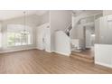 Open living room featuring light-toned walls, wood floors, a large chandelier, and stairway access at 236 W Calle Monte Vista Dr, Tempe, AZ 85284