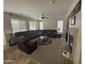 Spacious living room with a large sectional sofa, ceiling fan, fireplace, and plenty of natural light at 2670 S Dragoon Dr, Chandler, AZ 85286