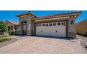 View of the garage featuring a paved driveway and white garage door with decorative windows at 26915 W Piute Ave, Buckeye, AZ 85396