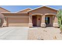 Attractive single-story home features a two car garage, a neutral stucco, and low-maintenance desert landscaping at 28834 N Spur Dr, San Tan Valley, AZ 85143