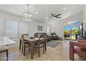 Open-concept living and dining area boasts tile flooring, recessed lighting, and sliding glass doors to the pool at 3175 E Merrill Ave, Gilbert, AZ 85234