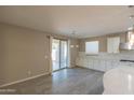 Bright kitchen area with access to patio, white cabinetry, stainless appliances, and tile flooring at 3796 E Rakestraw Ln, Gilbert, AZ 85298