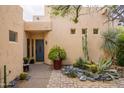 This home features a blue front door, stone pathway, and drought-resistant landscaping, creating inviting curb appeal at 39017 N Habitat Cir, Cave Creek, AZ 85331