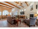 Inviting living room featuring wooden beams, a cozy fireplace, tile flooring, and an open floor plan at 39017 N Habitat Cir, Cave Creek, AZ 85331