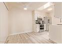 Modern white kitchen with stainless steel appliances, lots of sunlight, and updated flooring at 520 W Hononegh Dr # 2, Phoenix, AZ 85027