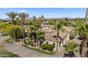 Aerial shot of a luxurious home with a tile roof, lush landscaping, and a circular driveway at 5615 N Invergordon Rd, Paradise Valley, AZ 85253