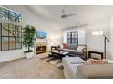 Bright living room featuring a fireplace, high ceilings, large windows, and comfortable seating at 5704 E Aire Libre Ave # 1246, Scottsdale, AZ 85254