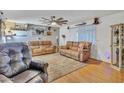 Inviting living room with wood floors, neutral paint, ceiling fan, and comfortable seating at 6749 E Ellis St, Mesa, AZ 85205