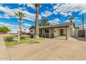 Spacious home with a large driveway and beautiful palm trees in a well-manicured lawn at 6907 E Portland St, Scottsdale, AZ 85257