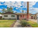 Charming single-story home with a well-maintained lawn and inviting desert landscaping at 6907 E Portland St, Scottsdale, AZ 85257