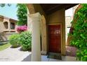 Inviting entryway with a solid wood front door and decorative column at 6945 E Cochise E Rd # 117, Paradise Valley, AZ 85253