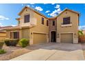 Inviting two-story home featuring a spacious three-car garage, stone accents, and a gravel front yard at 7220 W Ashby Dr, Peoria, AZ 85383
