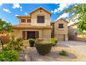Charming two-story home showcasing desert landscaping, mature bushes, and a well-manicured yard at 7220 W Ashby Dr, Peoria, AZ 85383