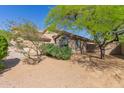 View of the rear exterior of the home with desert landscaping and mature trees providing shade and privacy at 10431 E Morning Star Dr, Scottsdale, AZ 85255