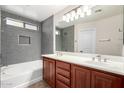 Modern bathroom with dual sink vanity, soaking tub, and a large vanity mirror at 12838 W Desert Mirage Dr, Peoria, AZ 85383