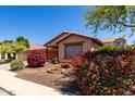 Charming home with colorful landscaping, a cozy bench, and a serene desert-scape design at 12838 W Desert Mirage Dr, Peoria, AZ 85383