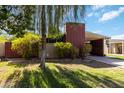 Attractive single-story residence showcasing a distinctive chimney and carport, surrounded by mature trees and bushes at 1329 E Catalina Dr, Phoenix, AZ 85014