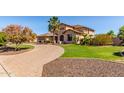 Gorgeous home with mature landscaping, a well-manicured lawn, and a circular brick driveway, creating great curb appeal at 14107 W Christy Dr, Surprise, AZ 85379