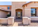 Inviting front porch with stone pillars and a decorative glass door, creating a warm welcome at 14107 W Christy Dr, Surprise, AZ 85379