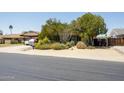 Landscaped front yard with mature trees, desert plants, and a charming single-story home at 15212 N 37Th Ave, Phoenix, AZ 85053