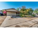 Single-story home boasts a covered carport and an expansive driveway leading to the entrance at 15212 N 37Th Ave, Phoenix, AZ 85053