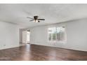 Bright living room with wood floors, ceiling fan, and sliding door to the backyard at 1643 W Naranja Ave, Mesa, AZ 85202