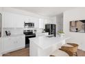 Modern kitchen features white cabinets, stainless steel appliances, and a spacious island with bar seating at 16875 N 12Th St # 31, Phoenix, AZ 85022