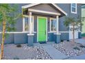 A close-up of the covered front porch featuring a bright green door, white trim, and decorative landscaping at 16875 N 12Th St # 33, Phoenix, AZ 85020
