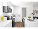 Bright white kitchen featuring stainless steel appliances, white cabinets, and modern countertops at 16875 N 12Th St # 33, Phoenix, AZ 85020
