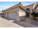 Home's front exterior with a three-car garage, desert landscaping, and a secure front entrance at 1896 E Stephens Dr, Tempe, AZ 85283