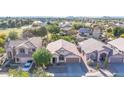 Overhead shot of a house in a well-maintained neighborhood with nearby green spaces and mountains at 19824 N 14Th Pl, Phoenix, AZ 85024