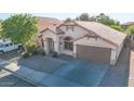 Beautiful view of the tan stucco home featuring a two car garage and a well manicured front yard at 19824 N 14Th Pl, Phoenix, AZ 85024