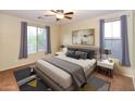 A primary bedroom featuring a ceiling fan, two windows, and neutral decor at 21050 E Tierra Grande --, Queen Creek, AZ 85142