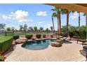 Inviting pool with rock features, surrounded by mature landscaping and overlooking the golf course at 22504 N San Ramon Dr, Sun City West, AZ 85375