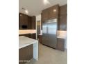 Modern kitchen with a large stainless steel refrigerator, sleek countertops, and plenty of storage at 24088 S 218Th Pl, Queen Creek, AZ 85142
