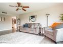 Cozy living room featuring comfortable seating, ceiling fan, neutral color scheme, and wood-look floors at 2430 E Hermosa Dr, Tempe, AZ 85282