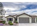 Inviting single-story home featuring a neat front yard, two-car garage, and desert landscaping at 27158 W Potter Dr, Buckeye, AZ 85396
