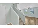 Light-filled staircase with carpeted steps, leading to an open living space with laminate floors and natural light at 3076 E Dunbar Dr, Phoenix, AZ 85042