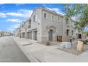 Street view of modern condo building with neutral color, individual garages, and sidewalk at 3076 E Dunbar Dr, Phoenix, AZ 85042