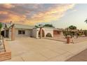 View of the home's front exterior showcases its white facade, brick accents, and low-maintenance desert landscaping at 3248 E Windrose Dr, Phoenix, AZ 85032