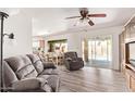 Inviting living room with wood-look flooring, plush seating, and sliding glass doors to the pool area at 3248 E Windrose Dr, Phoenix, AZ 85032