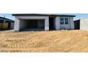 Exterior shot of home with an open garage, showing unfinished landscaping at 47333 W Coe St, Maricopa, AZ 85139