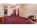Expansive living room featuring vaulted ceiling, large windows, neutral walls and carpeting, and a doorway at 610 S St Paul --, Mesa, AZ 85206