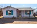 Quaint single-level house featuring vibrant blue shutters and a covered porch at 813 N Gilbert Ave, Casa Grande, AZ 85122