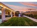 Spacious backyard with lush lawn, covered patio, outdoor seating, and built-in BBQ area, perfect for entertaining at 9721 E Juanita Ave, Mesa, AZ 85209