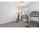 Dedicated exercise room featuring a treadmill, weights, and stylish chevron wallpaper at 9856 E Palladium Dr, Mesa, AZ 85212