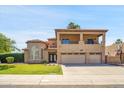 Two-story home with three-car garage, small front yard, and a second story patio at 10997 E Altadena Ave, Scottsdale, AZ 85259