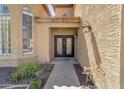 Home entrance with wrought iron double doors, small garden, and stone pathway at 10997 E Altadena Ave, Scottsdale, AZ 85259