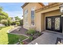 Close up of home's front door with wrought iron design and manicured landscaping at 10997 E Altadena Ave, Scottsdale, AZ 85259